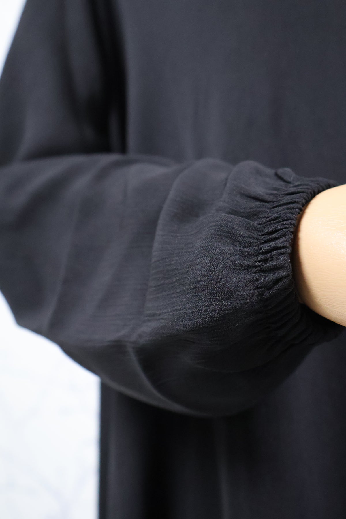 Detail van de mouw van de zwarte crêpe abaya met verfijnde afwerking - HBYA